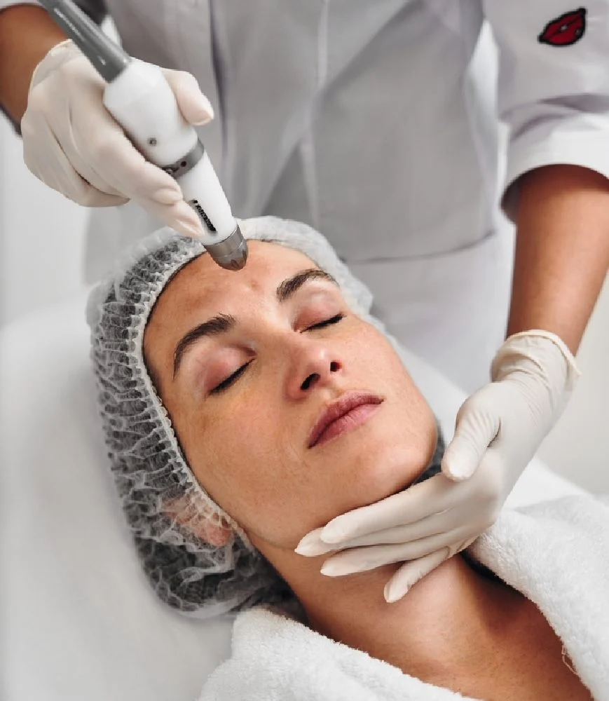 Inside a cosmetic hospital, a woman gets cosmetic surgery. She lays as the surgeon injects her with chemical.
