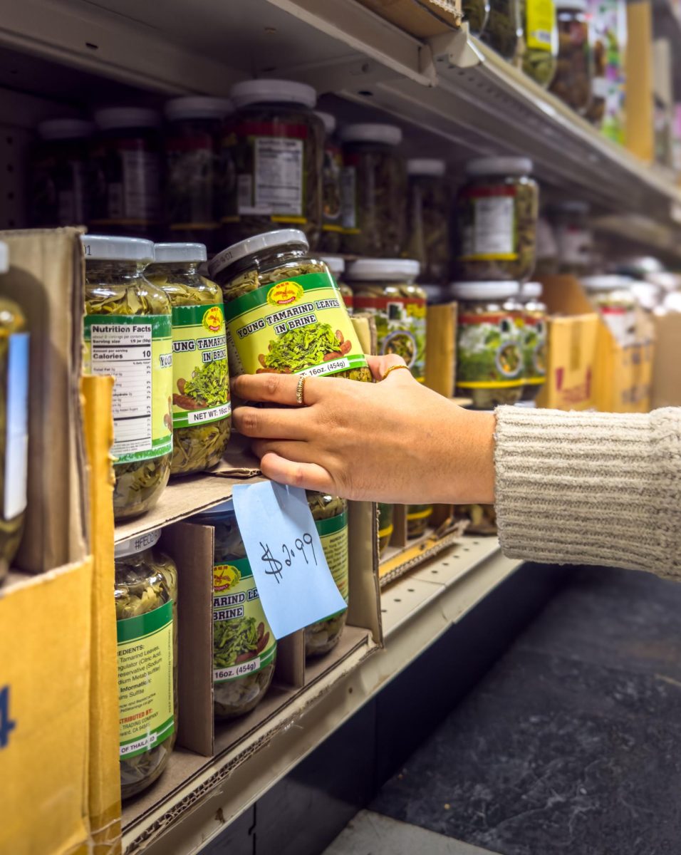 A customer grabs fermented tea leaves used for traditional Burmese dishes like Laphet Thoke.