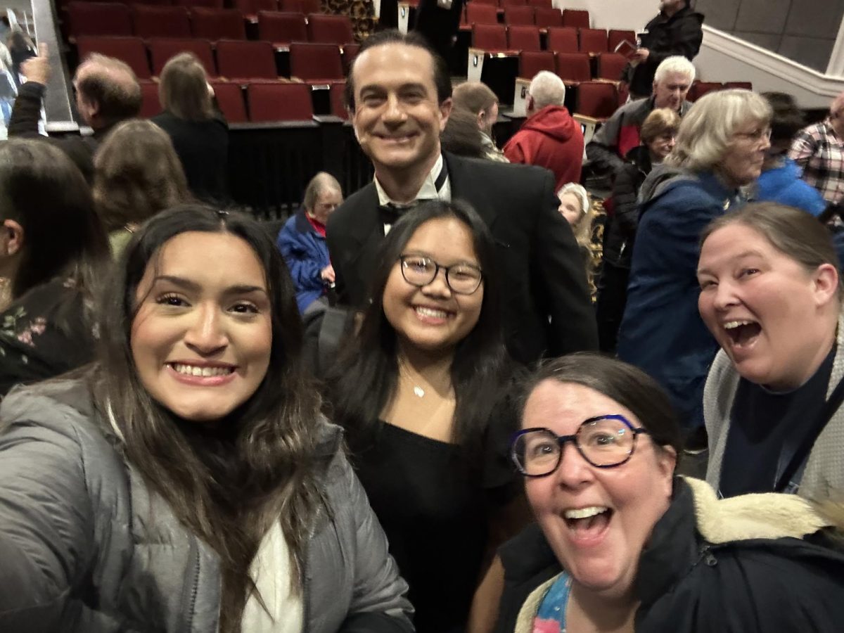 Sophia Rodriguez, Thatin Iang, Stefanie Davis and Jacqui Sheehan crowd around Benjamin Tatum to celebrate his performance.