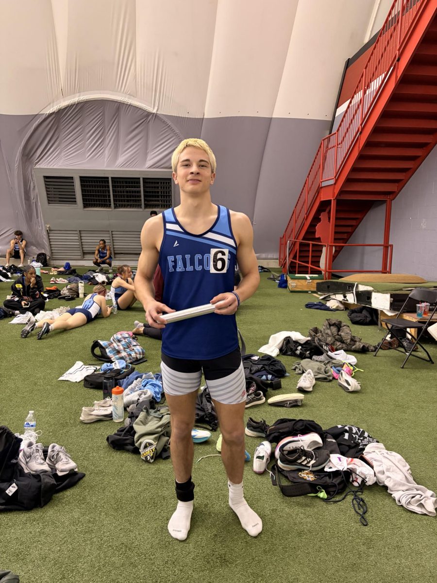 Uriah White at an UIndy indoor track meet holding a baton.